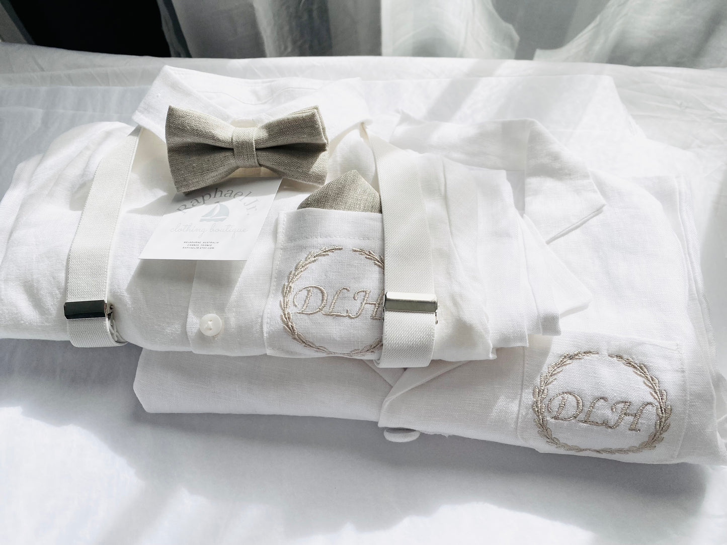 White linen shirt, pants, and beige bowtie, white suspenders, initials DLH embroidered on shirt and jacket, in beige gold thread.