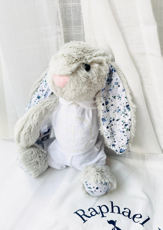 light grey fluffy bunny toy with floral ears, stitching in right ear saying Cruz.