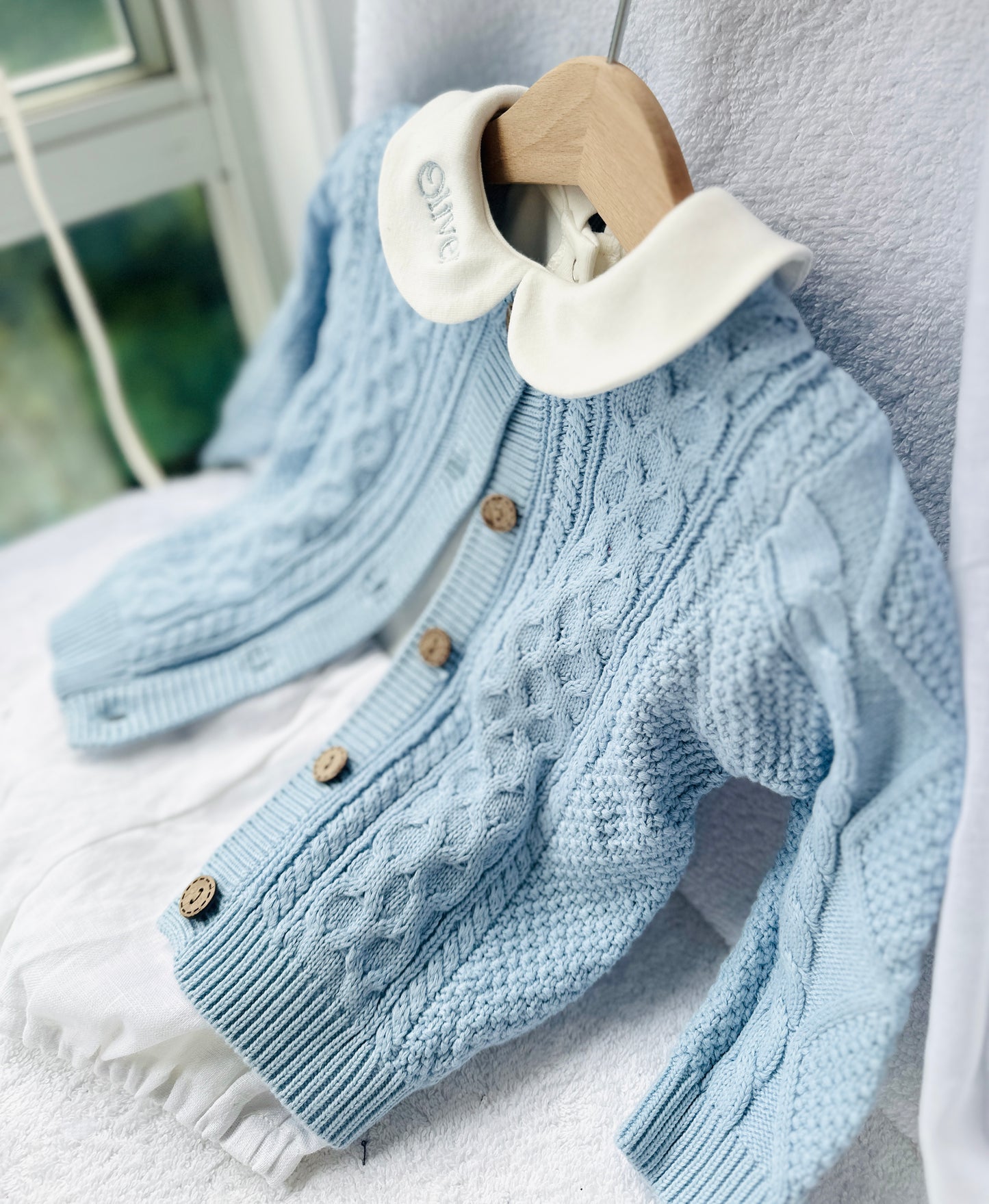 Baby outfit with blue cardigan, round collar bodysuit and white linen bloomers and long socks