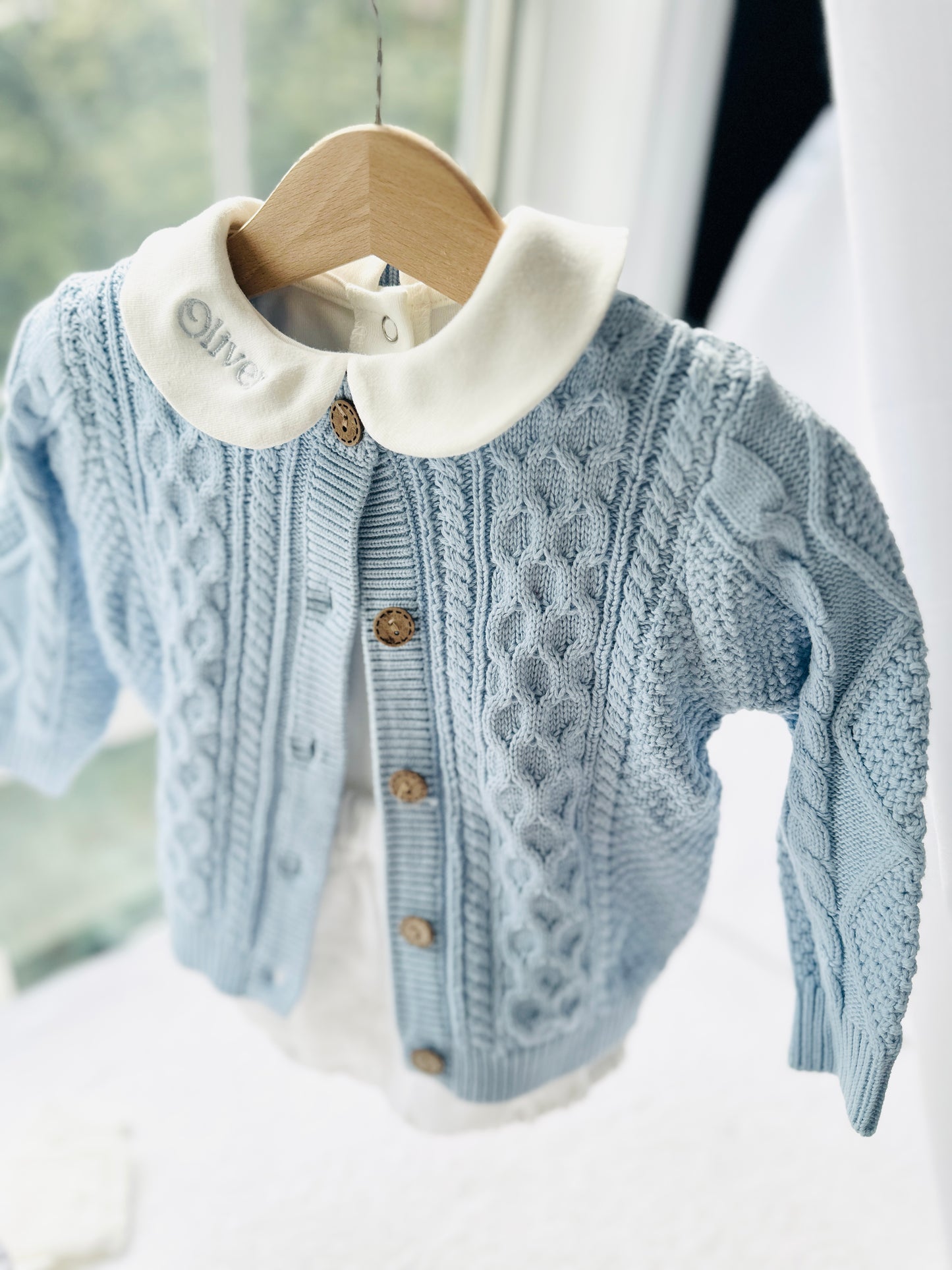 Baby outfit with blue cardigan, round collar bodysuit and white linen bloomers and long socks