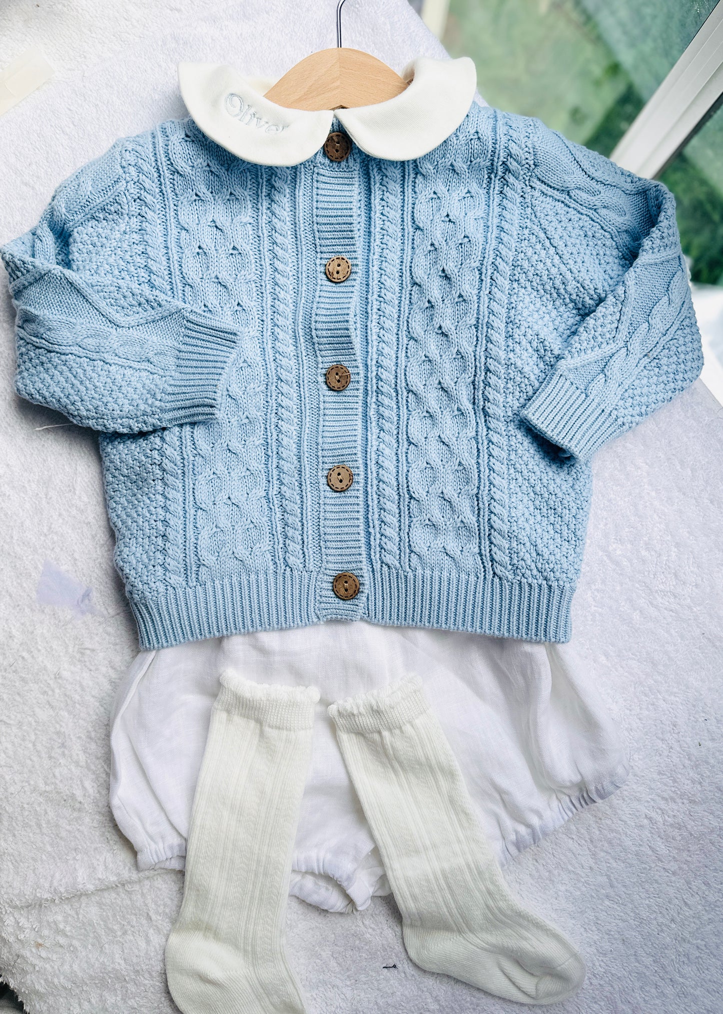 Baby outfit with blue cardigan, round collar bodysuit and white linen bloomers and long socks