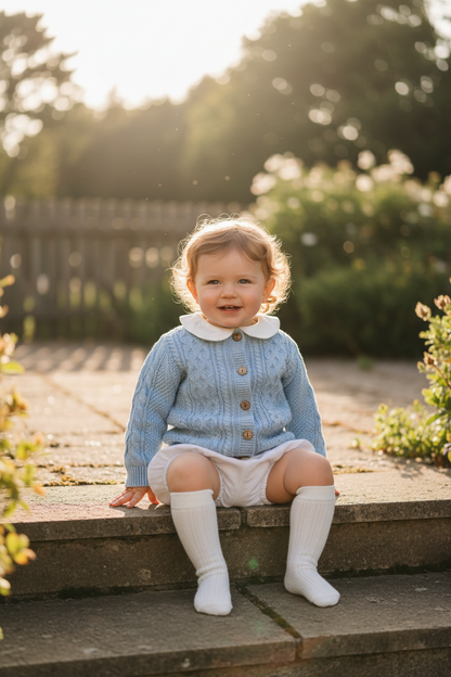 Baby outfit with blue cardigan, round collar bodysuit and white linen bloomers and long socks